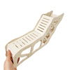 A hand is holding a light wood wooden hamster hideout cave with a peekaboo design.