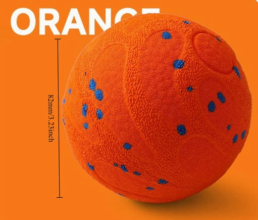 An orange, textured pet ball with blue dots is shown against an orange background.