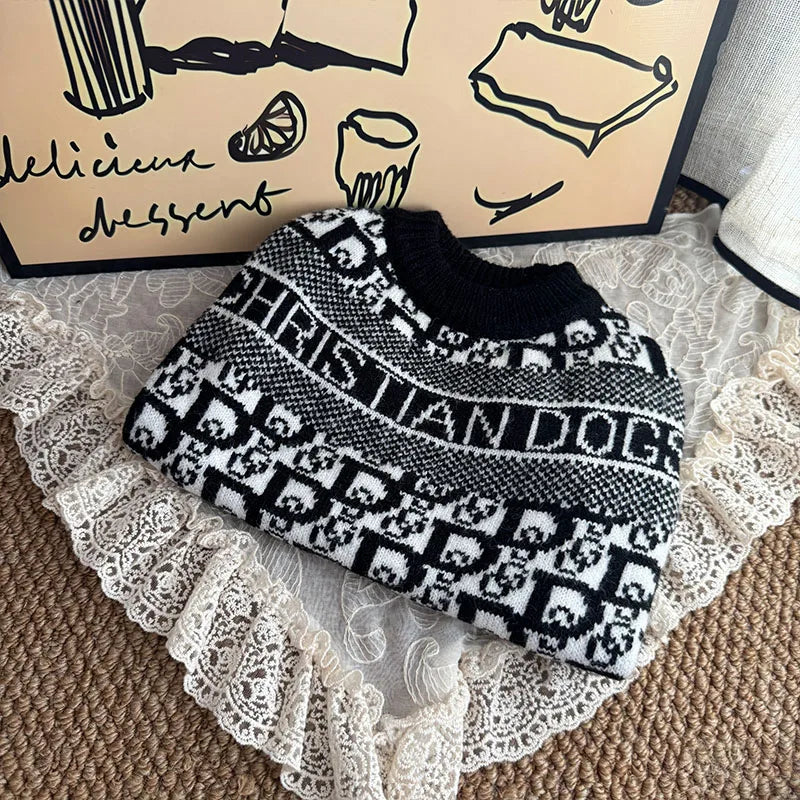 A black and white knit sweater featuring a dog pattern is displayed on a lace fabric.