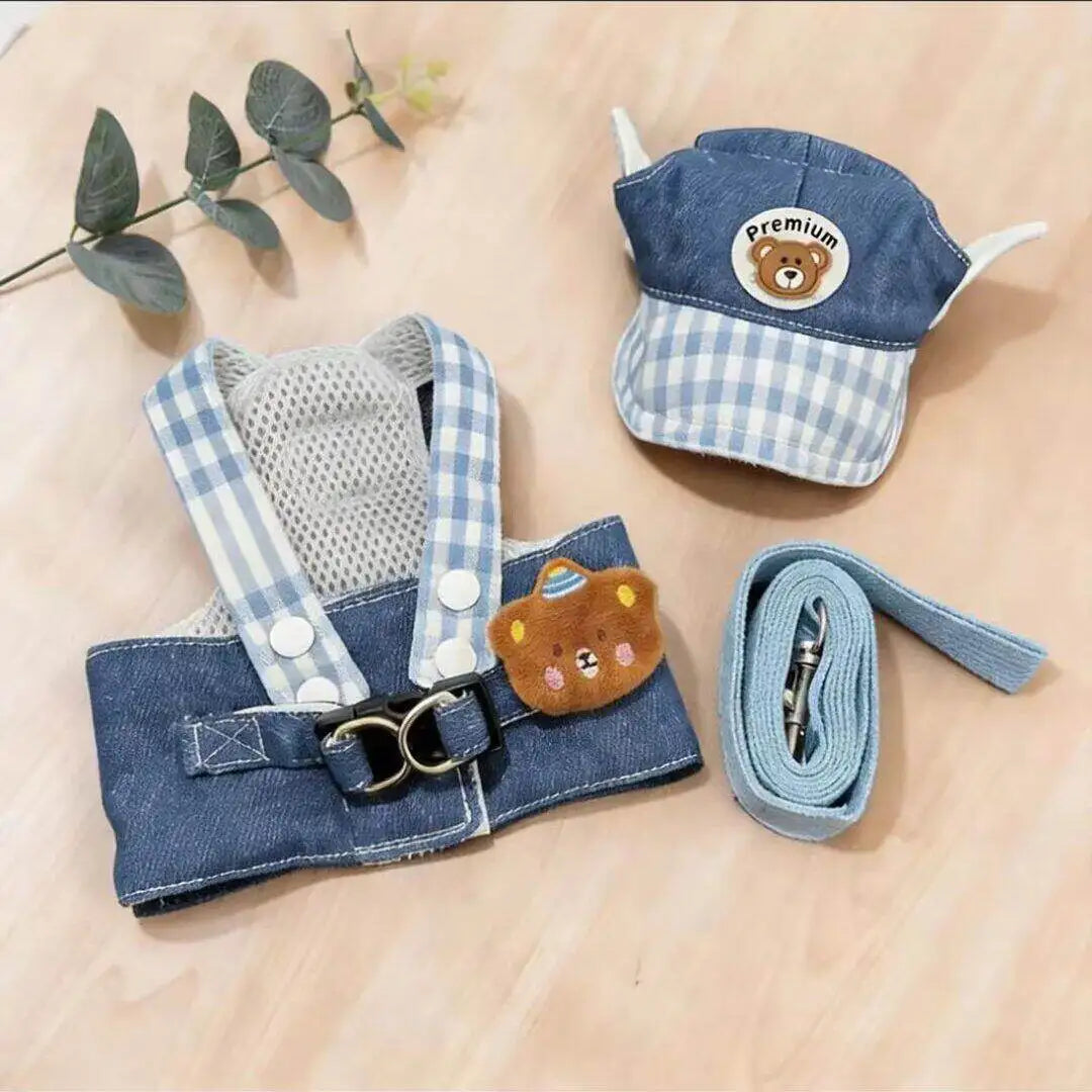 A blue and white checkered dog harness vest with a bear-themed fabric and attached leash.