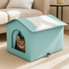 A light blue foldable waterproof insulated cat house with an arched entrance sits on a beige rug.