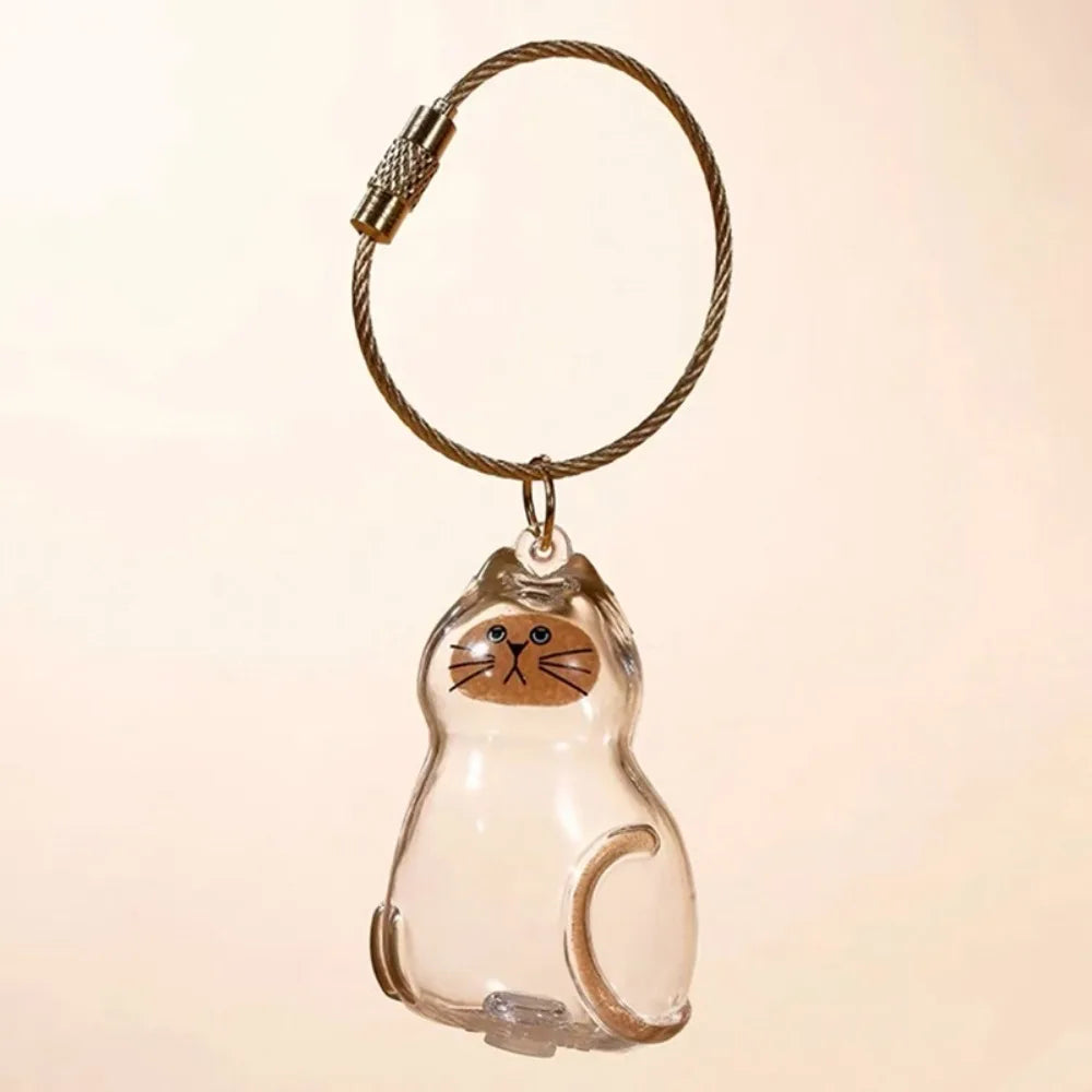 A clear, sculpted cat figurine keychain with a gold-colored leather cord and metal clasp.