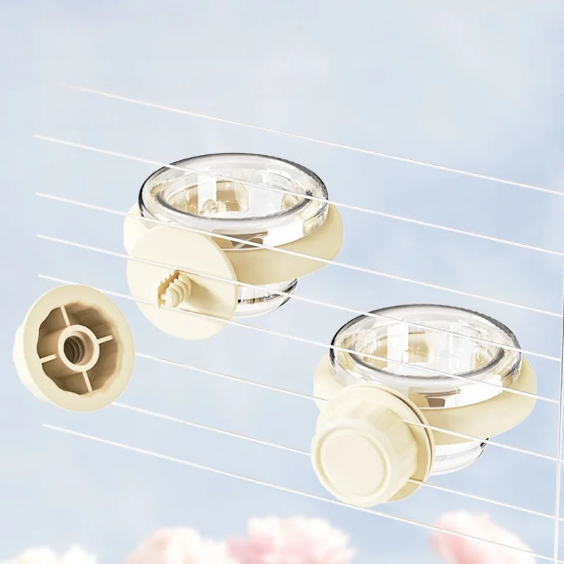 A transparent hanging bird feeder box with a light beige detachable design shown against a soft blue background.