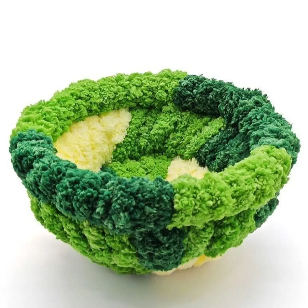A spherical bird hanging hammock made of green and dark green moss or plant material.