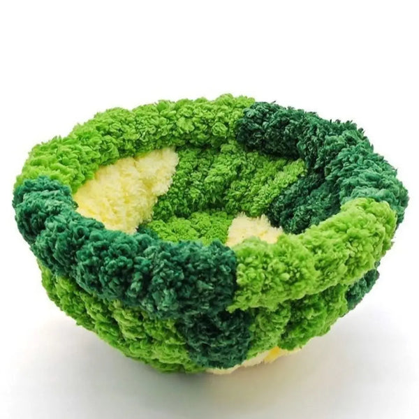 A spherical bird hanging hammock made of green and dark green moss or plant material.