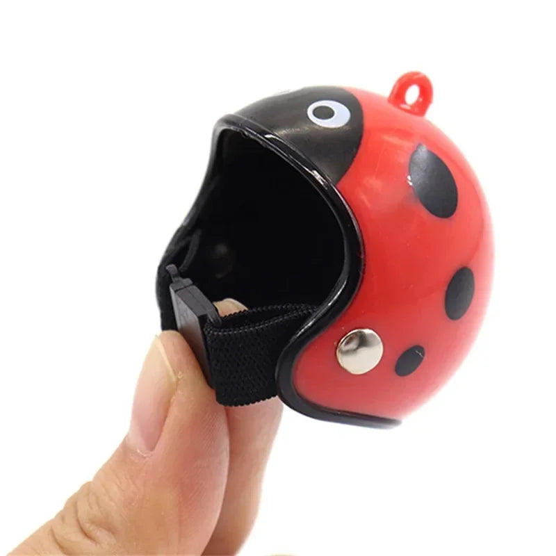 Ein rot-schwarz gesprenkeltes Geflügel-Helm wird von einer Hand gehalten.