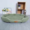 A light green corduroy pet sofa bed for dogs and cats resting on a gray surface.