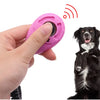 Pinker, verstellbarer Hundetrainer-Klicker wird von einer Hand gehalten, mit einem Hund im Hintergrund.