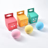 A set of colorful, box-shaped interactive cat sounding toys in pink, orange, and teal, along with a blue ball.