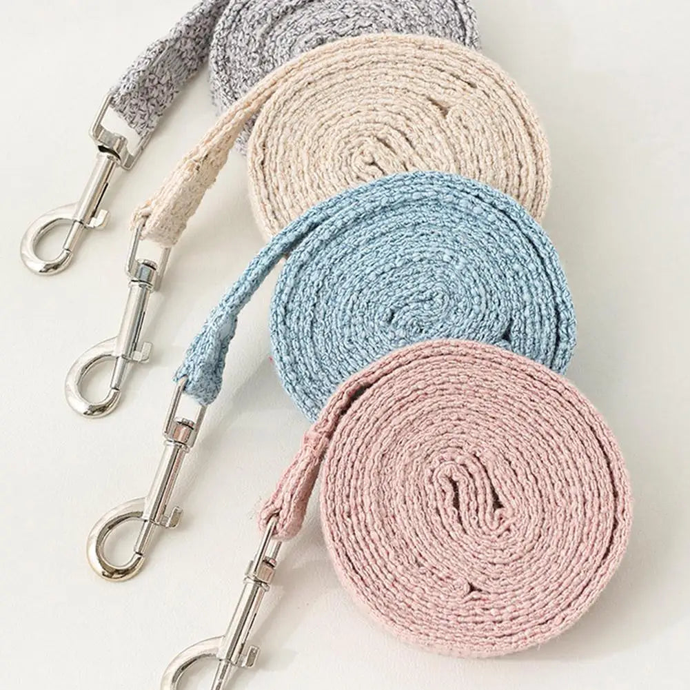 A stack of pet leash harnesses in various neutral tones including gray, beige, and light blue.