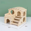 A natural wooden hamster house and activity platform with a roof and stairs, shown against a green background.