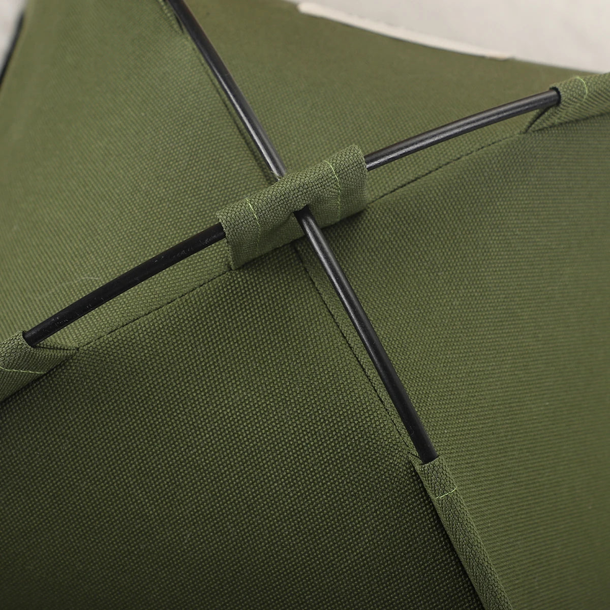 A close-up of a olive green cozy pet tent bed for cats showing the fabric and a black strap detail.