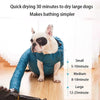 A small white dog is sitting inside a blue foldable drying bag on a wooden floor.