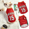 A small dog wearing a red sports jersey with the number 15, featuring the text MEXICO.