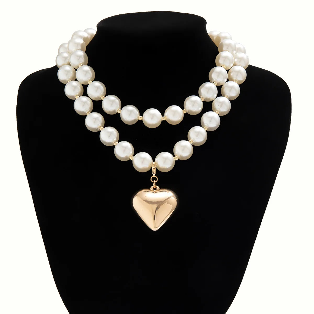 A choker necklace featuring multiple strands of white pearls culminating in a gold heart pendant.