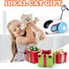 A young girl is smiling while holding a kitten, with an automatic pet toy car for cats and dogs visible in the background.