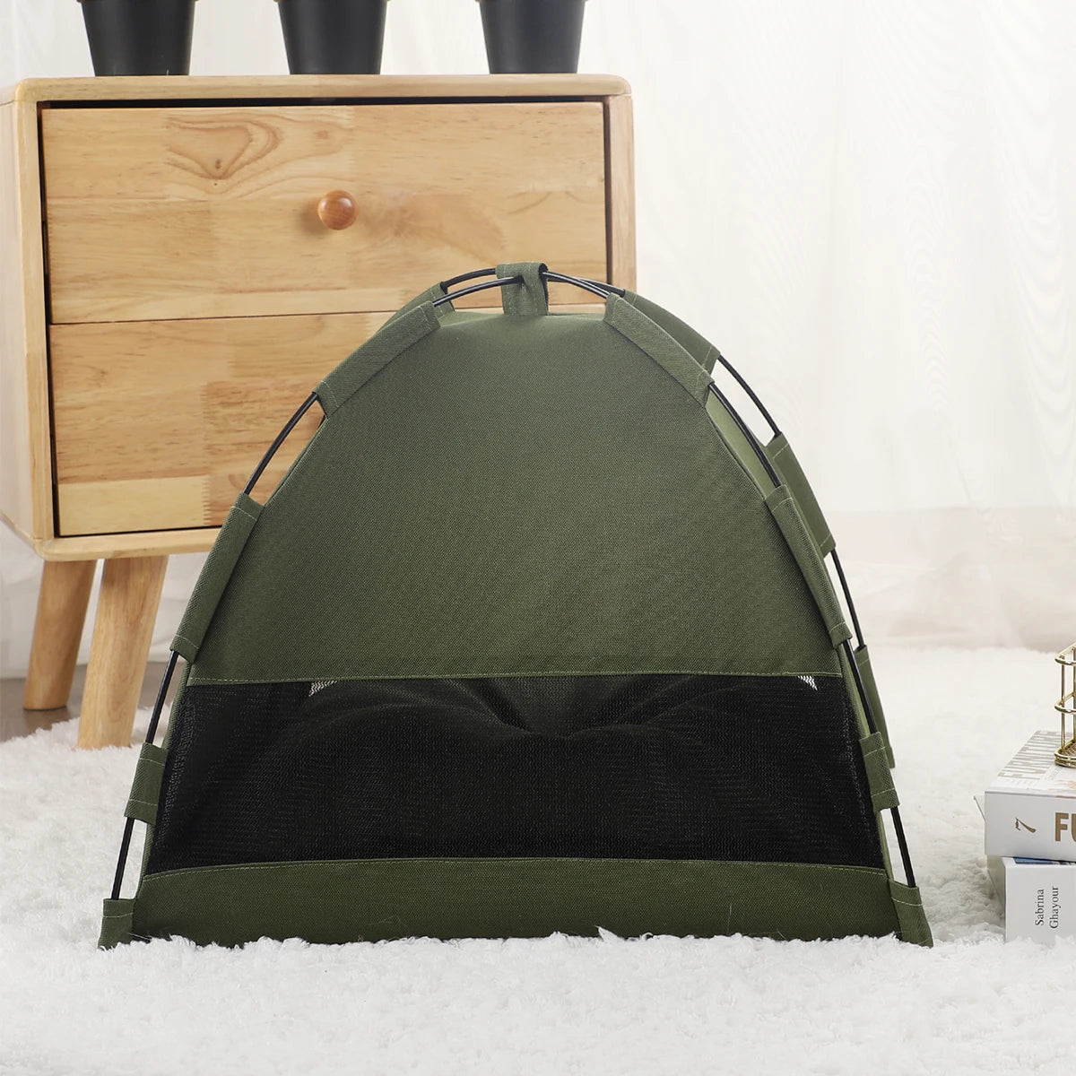 A dark olive green cozy pet tent bed for cats resting on a white fluffy surface.