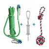 A green cotton rope dog spring pole toy with metal clasps and a red, white, and green ball of yarn.