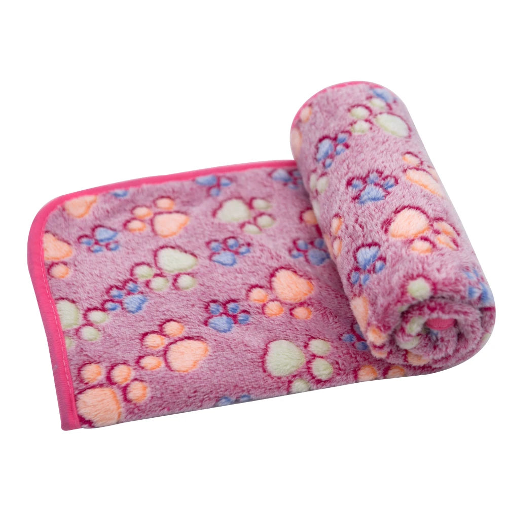 A rolled pink and purple fluffy pet blanket or mat with floral patterns.