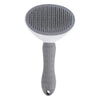 A gray pet hair remover grooming brush with a perforated silicone head and a textured handle.