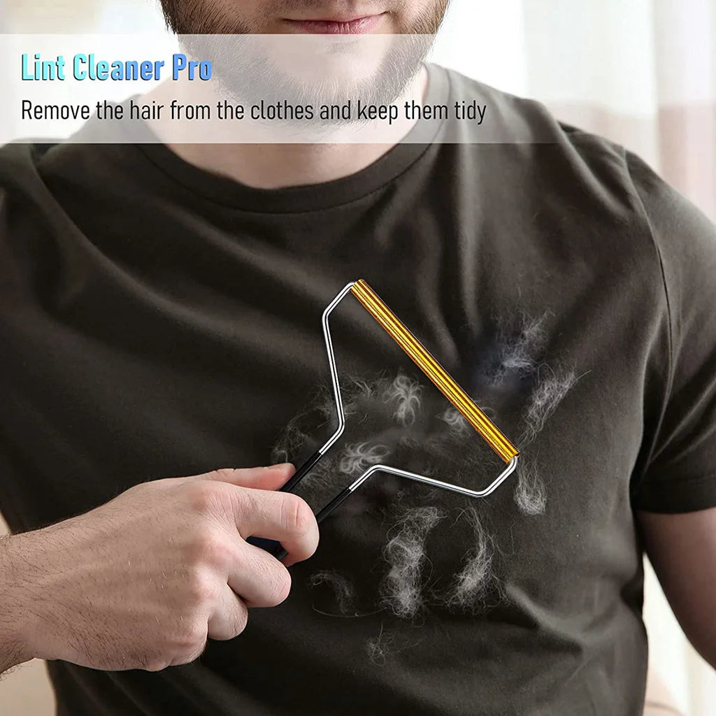 A hand holds a metal lint remover brush against a dark shirt, removing pet hair from the fabric.