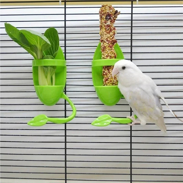 A white bird is feeding from a green shuttlecock style cuttlebone stand with sunflower seeds.