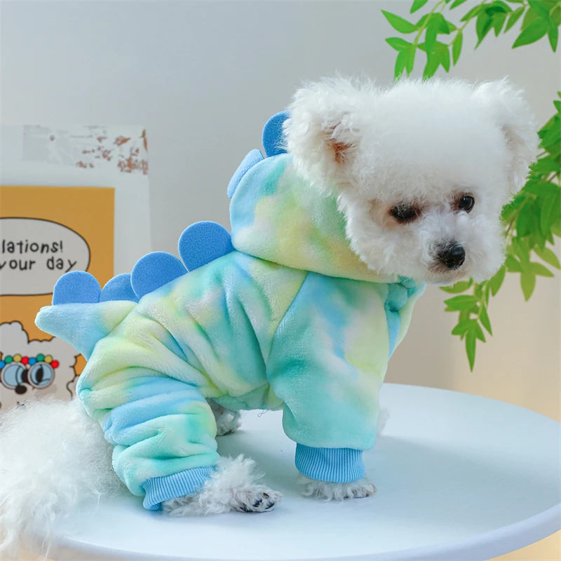 A white fluffy dog plush wearing light blue and green patterned fleece overalls.