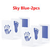Two white cards showing blue handprints and footprints for baby keepsakes