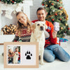 A family of three posing with a golden retriever in front of a wooden frame featuring a black paw print.