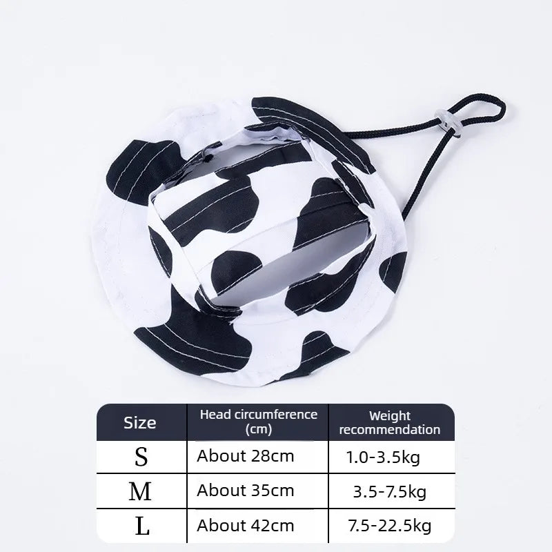A white and black cow print pet bucket hat shown flat lay with a size chart.