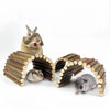 A brown rabbit is interacting with a woven archway made of natural wood branches for chew toys.