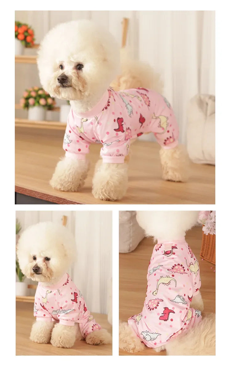 A fluffy white dog wearing pink patterned cotton pajamas.