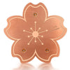 Un disque de cuivre rond avec un design floral et trois points de support.