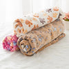 Rolled fleece pet bed mats in various colors including orange, beige, and pink resting on a white surface