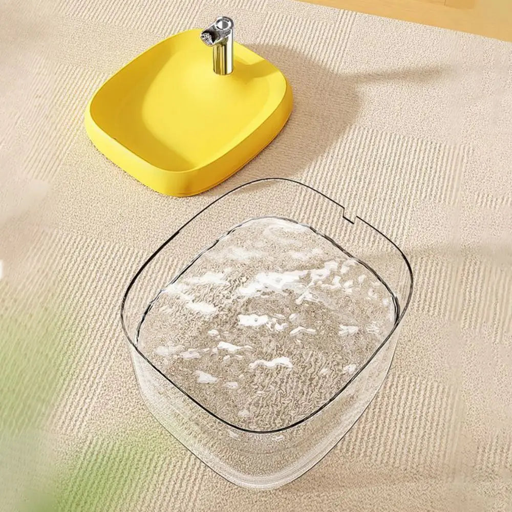 A yellow cat drinking fountain with a metal spout is shown on a light-colored surface.