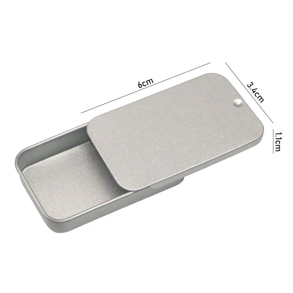 A silver compact sliding lid tin box with dimensions 6cm by 3.4cm and 1.1cm thick.