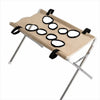 A beige pet grooming hammock with black rings is shown attached to a silver stand.