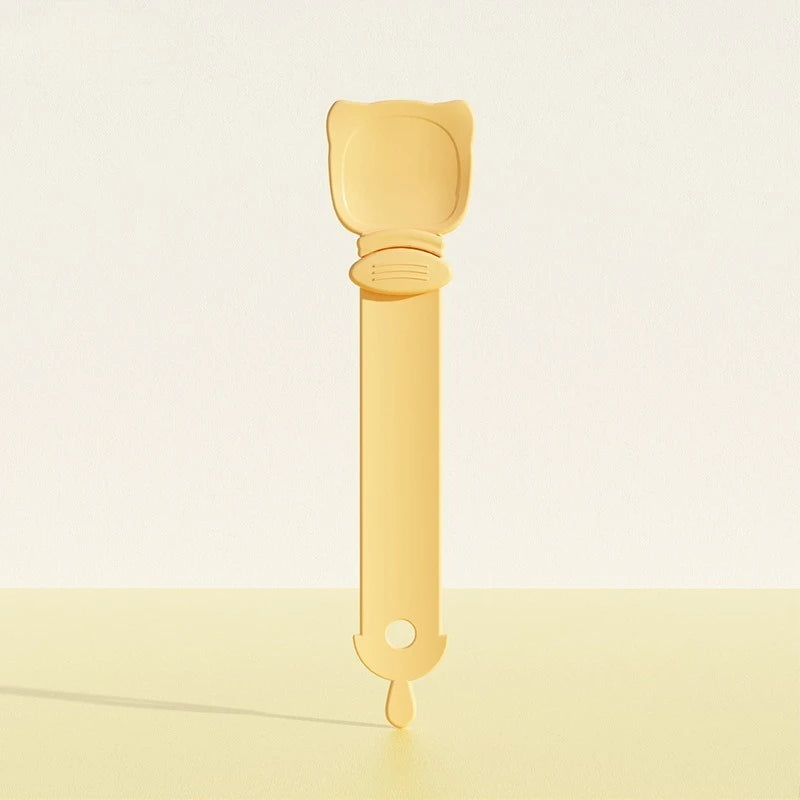 A light yellow long-handled pet food dispensing spoon with a rounded handle and a tapered end.