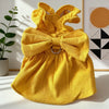 A bright yellow vintage corduroy pet dress featuring a bow and ruffle skirt, displayed on a white surface.