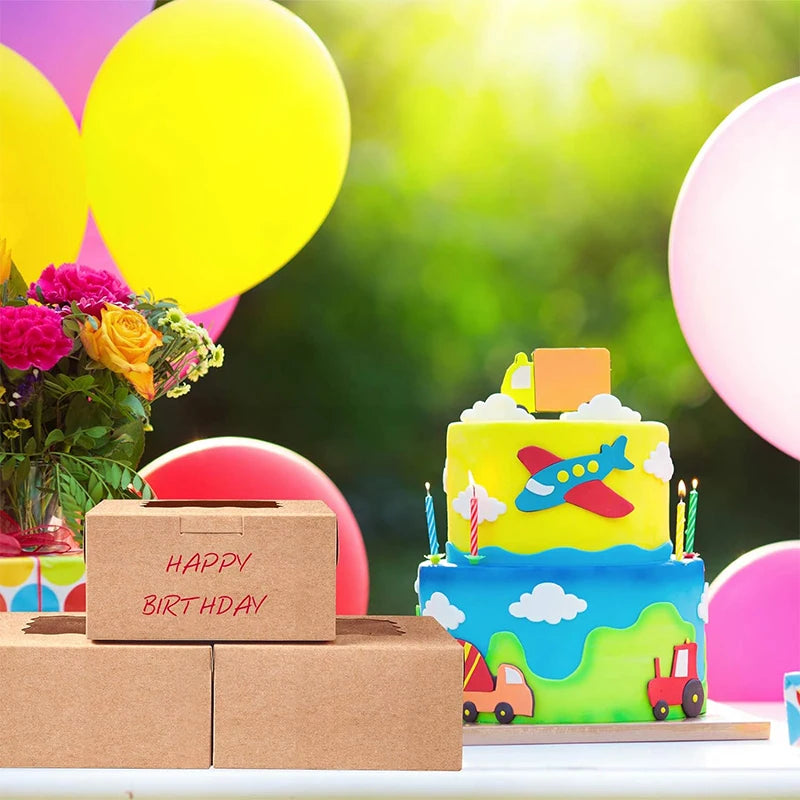 A colorful birthday cake decorated with clouds and an airplane, placed next to cardboard boxes.