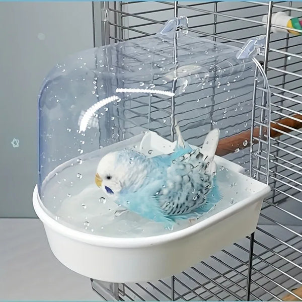A clear plastic bird bath with a dome, containing a small blue and white bird inside a wire cage.