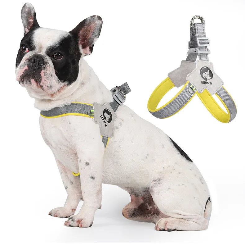 A white and black bulldog wearing a yellow adjustable dog harness vest with reflective mesh.