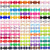 A pack of 100 polka dot pet bows in various colors and patterns with rubber bands for dog hair accessories