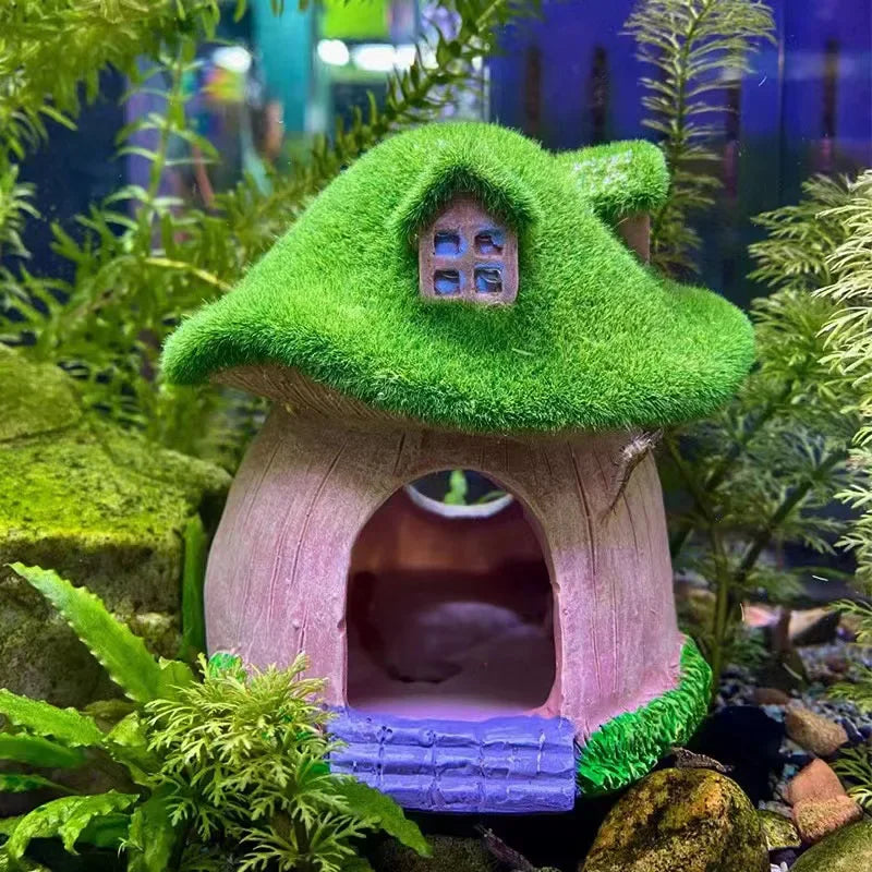 A miniature resin aquarium house decor with a green roof and pink walls, featuring an entrance for small fish.