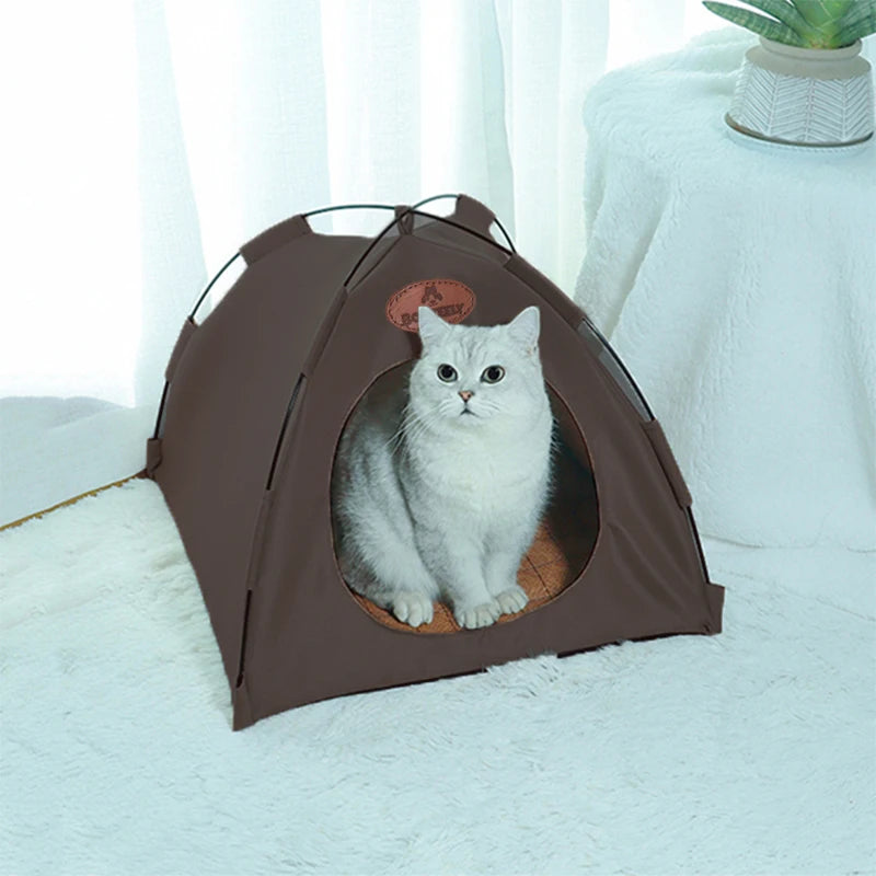 A brown foldable pet tent for cats is shown resting on a white fluffy surface.