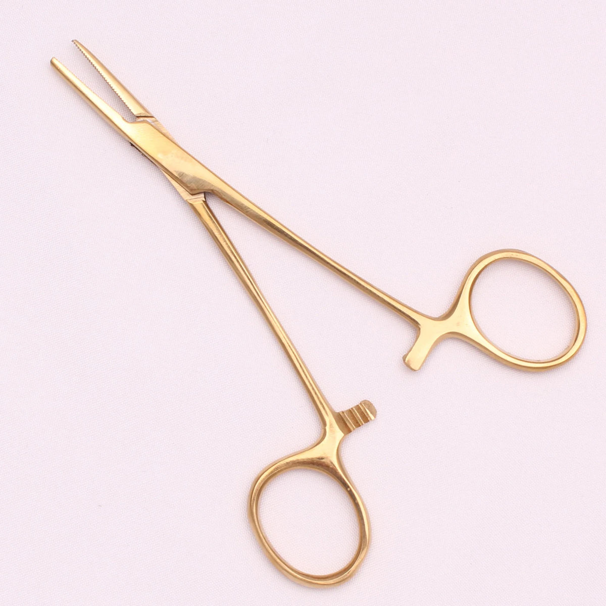 A pair of gold-toned stainless steel pet forceps with fine tips and a small clamp.