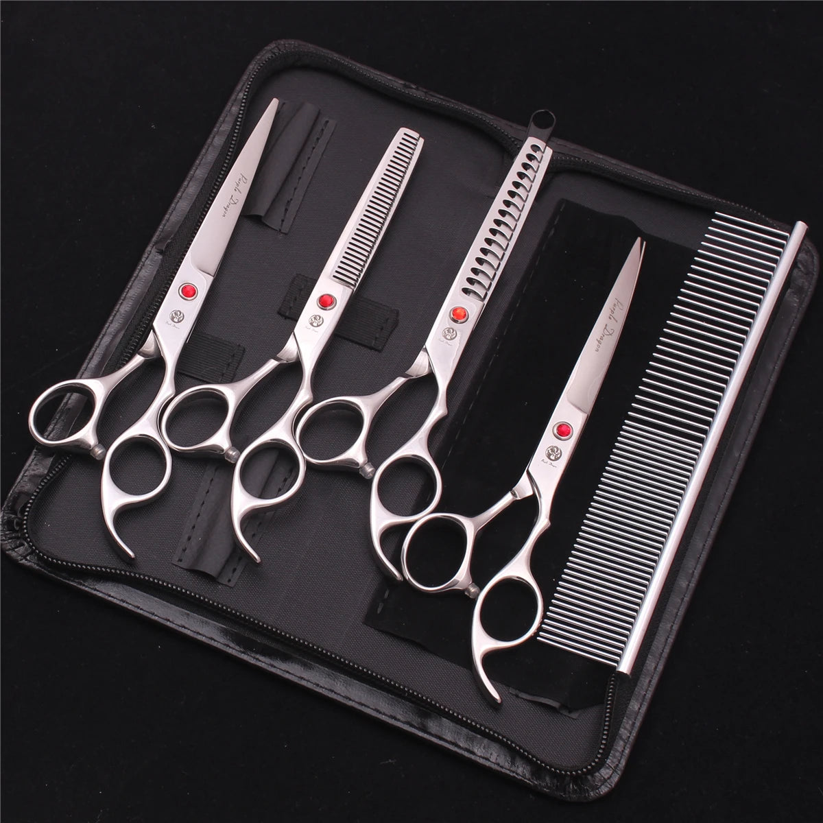 A professional stainless steel pet grooming scissors set with various blades and a comb displayed in a black case.