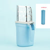 A light blue plastic container holding a stainless steel cat litter shovel with a refill bag and a separate roll of random co