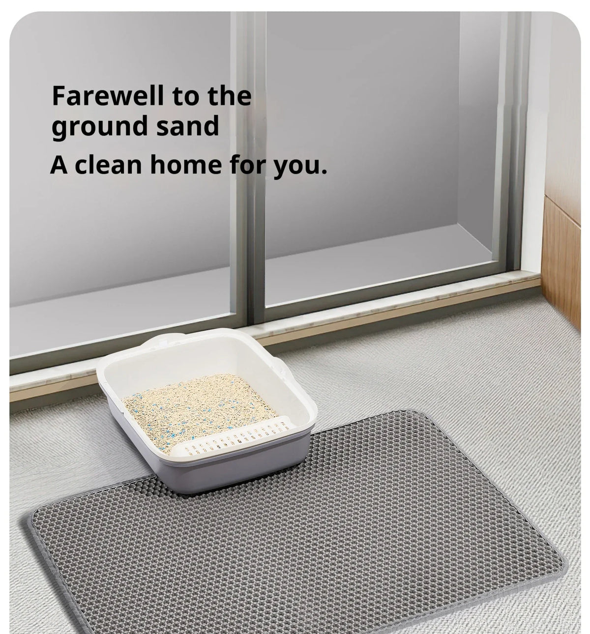 A white honeycomb cat litter mat placed on a gray mat in front of a window.
