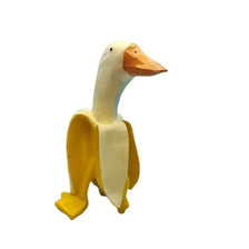 Escultura de resina amarilla y blanca de un pato con pico naranja, similar a una figura de jardín.
